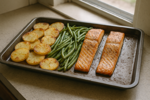 Ovenschaal met zalm, kruidige aardappelschijfjes en boontjes