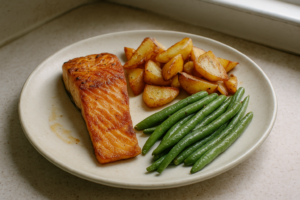 Zalm met gebakken aardappeltjes en sperziebonen op een bord