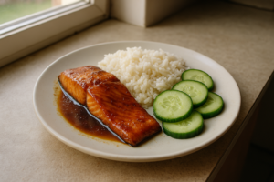 Bord met zalm teriyaki, rijst en komkommer in een frisse setting
