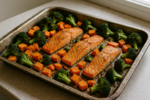 Zalm met zoete aardappel en broccoli uit de oven op een bakplaat