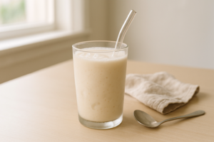 Glas milkshake op een lichte keukentafel in daglicht, als eenvoudige optie bij lactose-intolerantie